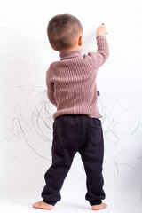 Innocent and lovely children scribble on the white wall
