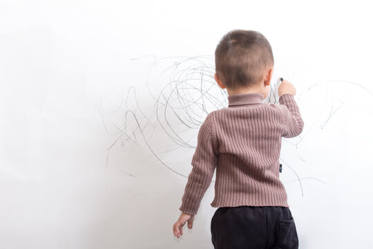 Innocent and lovely children scribble on the white wall