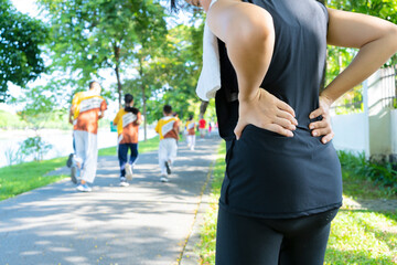 Young female runners exercise in the park And having severe back pain from running