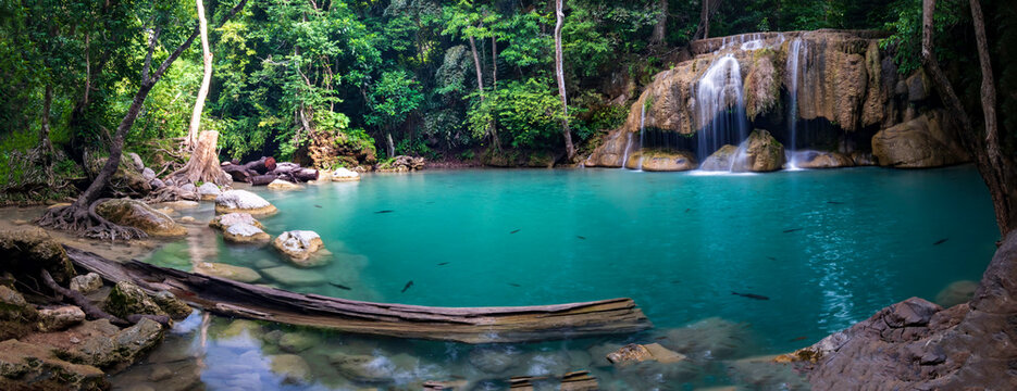 Panorama photo of erawan waterfall in the tropical jungle surrounded by a natural with turquoise clear fresh water and green forest in kanchanaburi, thailand.