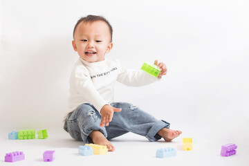 A cute two-year-old boy playing with a toy