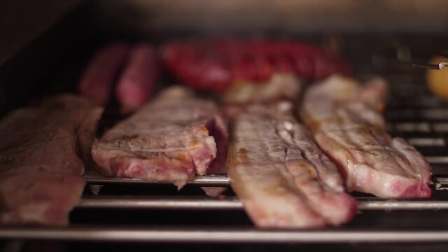 cooking grilling steak sausage on a grill  slow motion