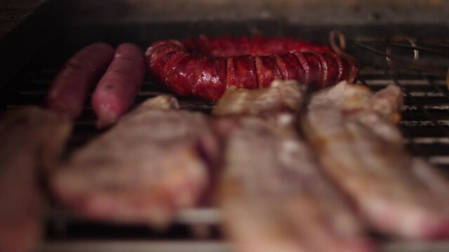cooking grilling steak sausage on a grill  slow motion