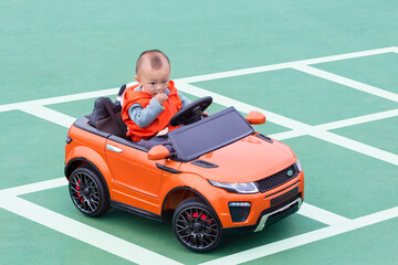 A kid driving a toy car