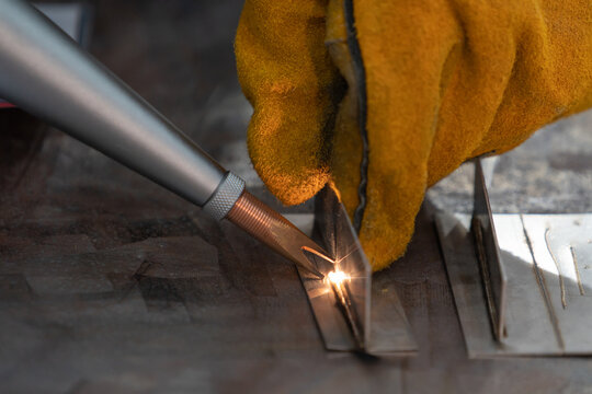 Laser welding machine in a factory. Industrial worker works with welding and cutting machine in a factory.