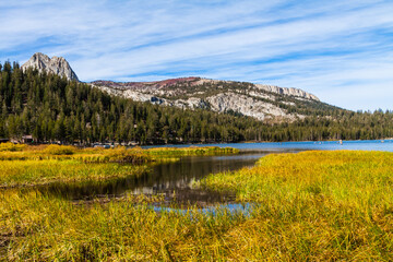 Fototapeta premium Linia brzegowa jeziora Mary wypełniona trawami z kryształową turnią i grzebieniem mamuta w oddali, Mammoth Lakes, Kalifornia, USA