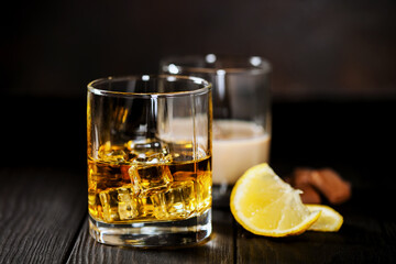 Whisky with ice and a lemon and creamy liqueur with chocolate
