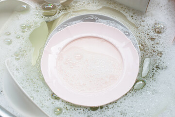 Obraz na płótnie Canvas Washing dishes, Close up of utensils soaking in kitchen sink.
