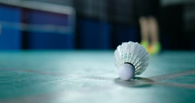 Badminton shuttlecock on a green floor 
