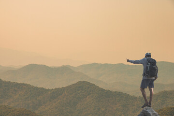 Young man standing on top of the mountain