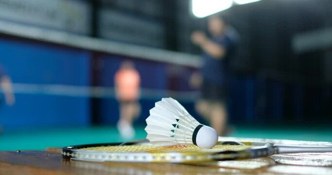 Badminton shuttlecock and racket with blur player background

