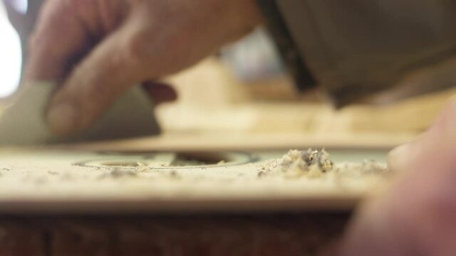 Craftsman artisan file wood with sharp knife to make guitar slow motion