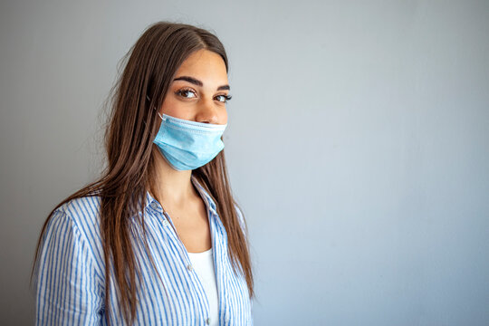 Young Woman Wears Protective Face Mask, Wrong Way, Incorrect Wearing - Masks Should Cover Nose As Well. How To NOT Wear A Mask. The Wrong Way To Wear A Mask On The Chin And Open Nose