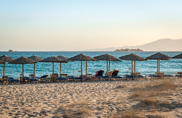 Fototapeta premium View of Plaka beach, with sunbeds and umbrellas, in the afternoon. Naxos island, Greece