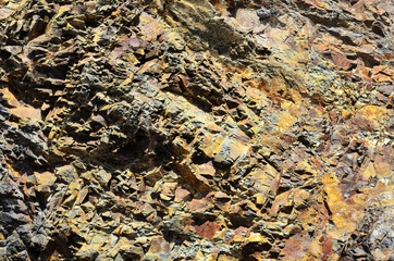 Texture of a relief rock made of yellow and brown stone. Geology.