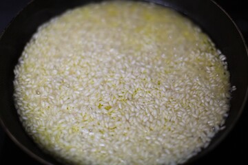 Risotto cooking in a cast iron skillet pan. Italian food.