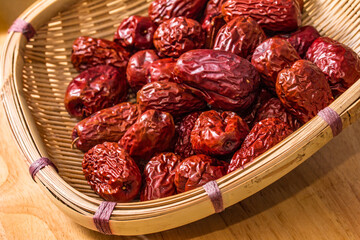 The bamboo dustpan is filled with bright red Xinjiang dates