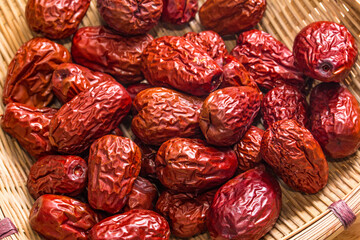 The bamboo dustpan is filled with bright red Xinjiang dates