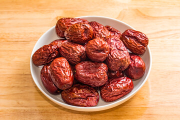 The bamboo dustpan is filled with bright red Xinjiang dates