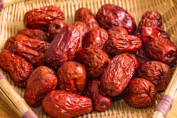 The bamboo dustpan is filled with bright red Xinjiang dates