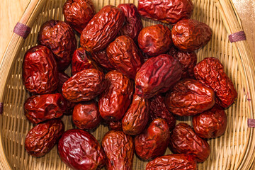 The bamboo dustpan is filled with bright red Xinjiang dates