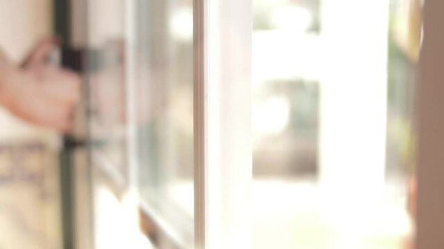 young man closing balcony sliding window door slow motion