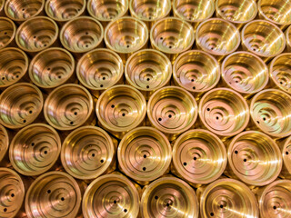 an abstract perspective industrial close-up background of shiny brass metal threaded hexagonal...