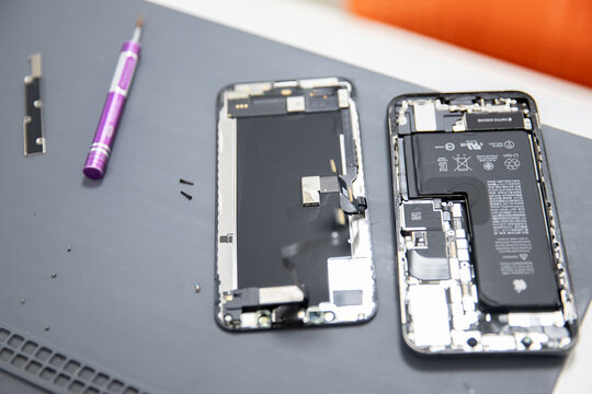 RUSSIA - July 27, 2020: Repair iPhone apple broken phone screen and replace used rechargeable batteries for recycling