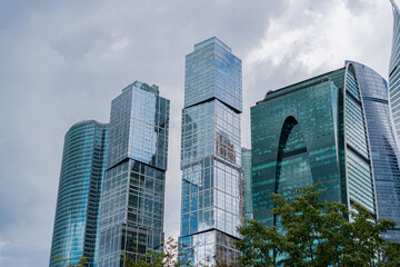 Obraz premium skyscrapers Moscow City in summer framed by tree branches