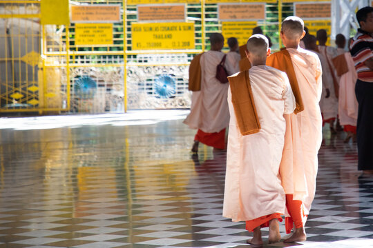 pretty young teenage nuns in pink uttarasanga visiting Shwethalyaung reclining buddha temple in Bago (Pegu), Myanmar