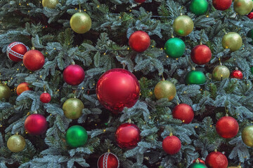 Bright Christmas balls on a decorated Christmas tree on a sunny day, background