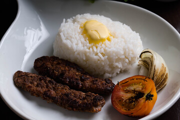 beef kebab with buttered rice, grilled tomato and onion