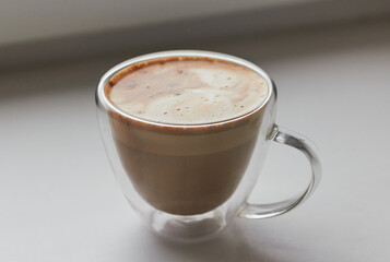 cappuccino coffee in a glass coffee cup with foam