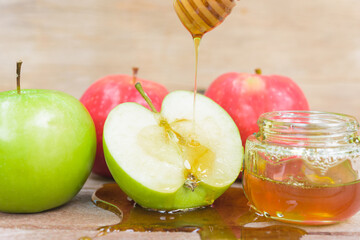 Jewish holiday, Apple Rosh Hashanah, the photo have honey in jar and drop honey on green apples on wooden background