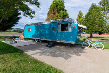Shiny blue travel trailer on a concrete pad with bicycles © davidrh