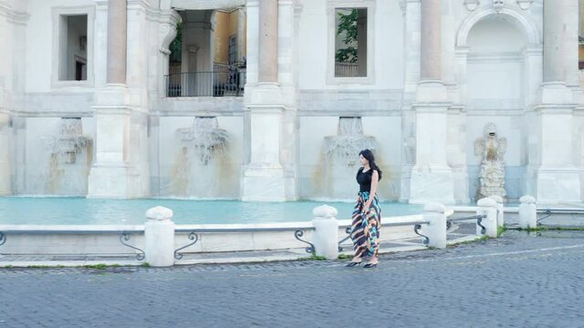 slow motion on beautiful elegant woman walking around the janiculum fountain