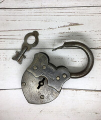 An old lock and a key on white