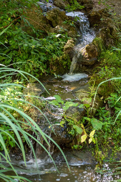 small river running on a stone way in the middle of the day sun