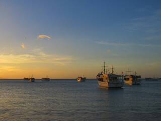 Fototapeta premium The warm sunset during the summer days becomes a spectacle of colors and sensations on the beaches of the Caribbean while we enjoy it and renew our vital energy