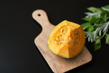 カッティングボードにのせたカボチャ_黒背景