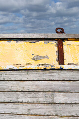 Abandoned fishing boat on the shingle beach at Dungeness with weathered and broken timbers.