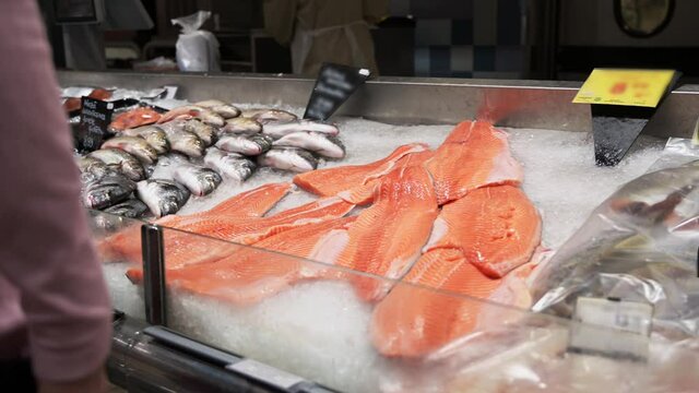 many raw fish on crushed ice bed in the fishmarket. Group of different fish, dorada and salmon on ice.