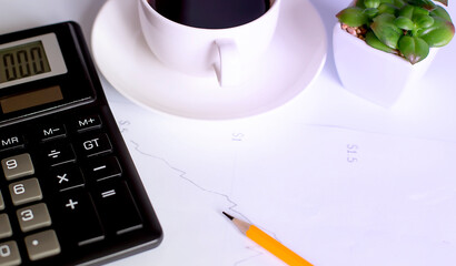 Cup from coffee, the calculator on documents.