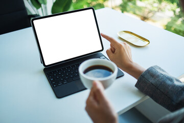 Mockup image of a woman using and pointing finger at tablet pc with blank desktop white screen as a computer pc