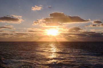 Obraz na płótnie Canvas dramatic clouds sea sunset with sunrays