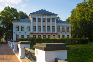Obraz premium the former city Duma Building in a Park among green trees with reflection in the pond against a blue sky and a space for copying on a summer day Uglich Russia