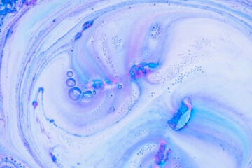 Beautiful bath bomb dissolves in blue and pink colors in the water. Abstract texture background