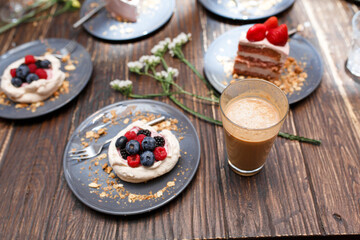 Sweet cakes with summer berries on a wooden table. Party, sweet table. Summer offer desserts in the restaurant.