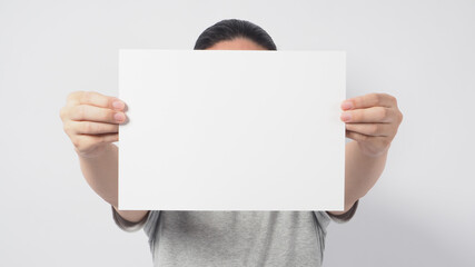 Male model's hands is holding the A4 paper and wear gray t shirt on white background.