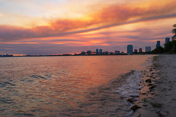 Miami city skyline panorama with urban skyscrapers over sea with reflection. Miami city night.
